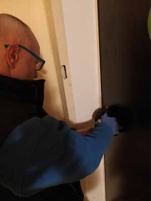 Ein Schlüsselscout24-Mitarbeiter öffnet die Tür mit einem Werkzeug.